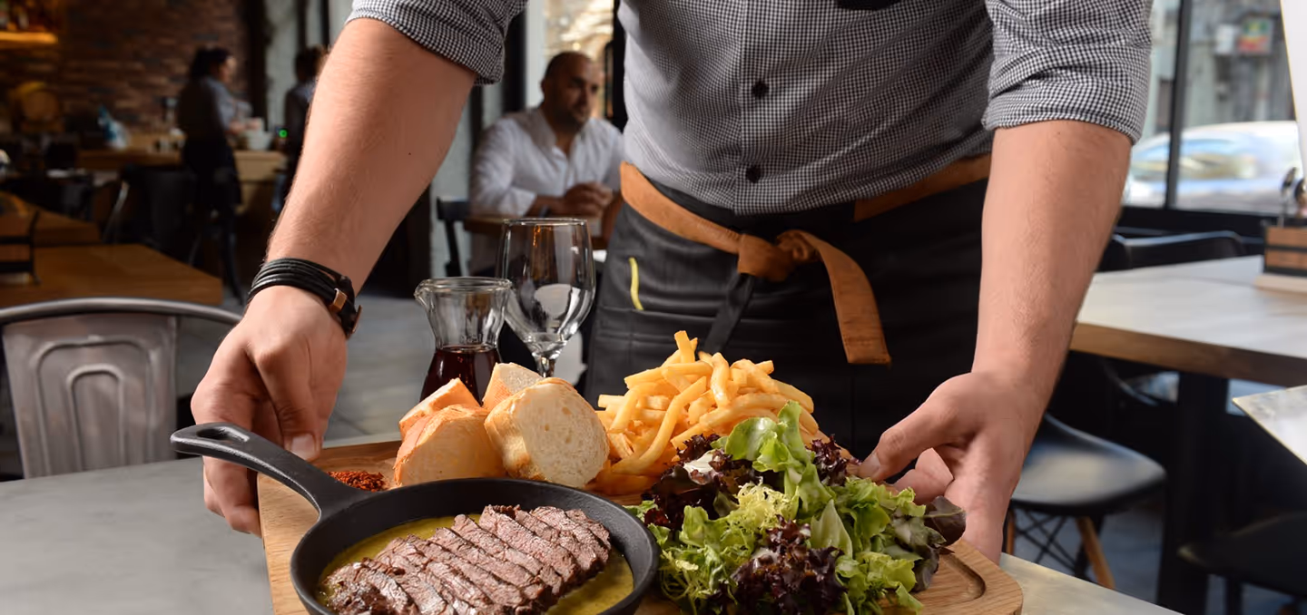 Restaurant server presenting a freshly prepared meal